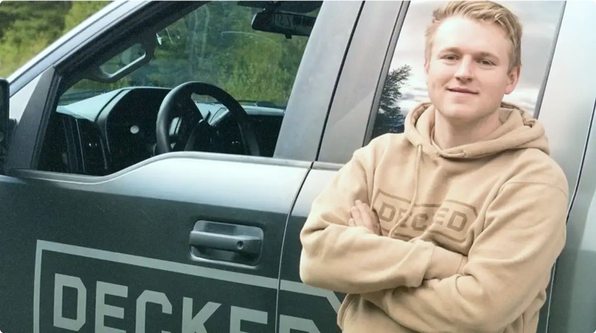 decked-homepage-poster Guy standing next to "Decked" truck
