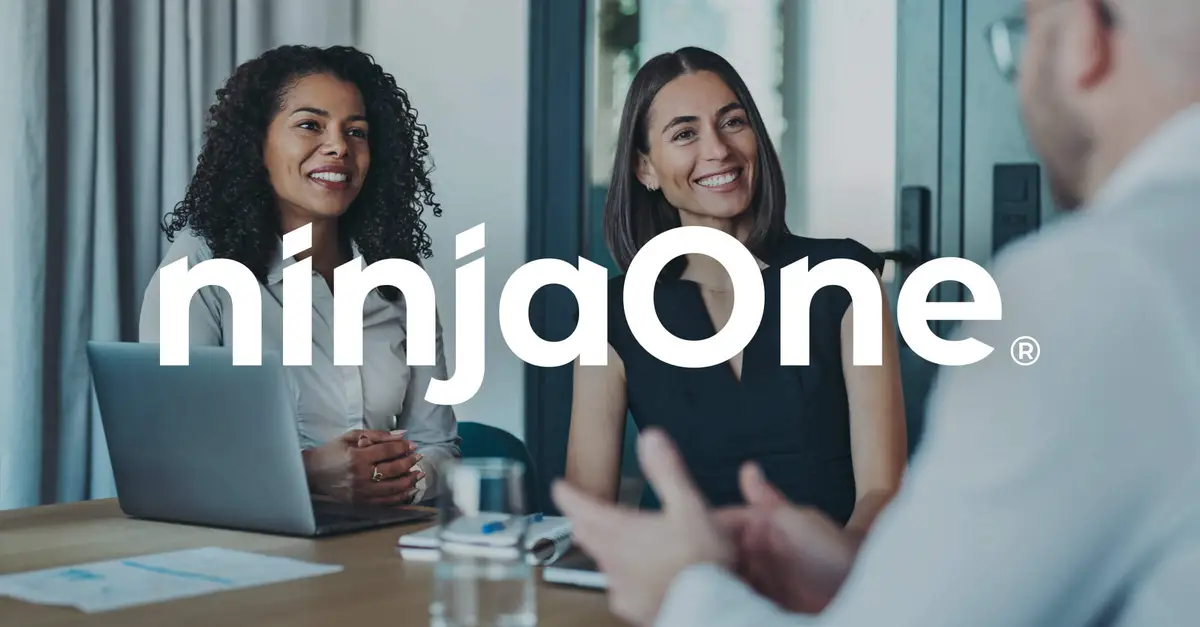 compañeros de trabajo sentados juntos en una mesa hablando y sonriendo