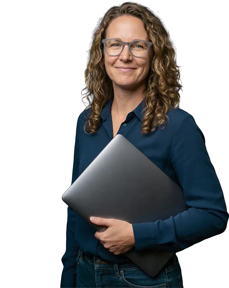 IT professional smiling and holding a laptop, representing NinjaOne automation use cases